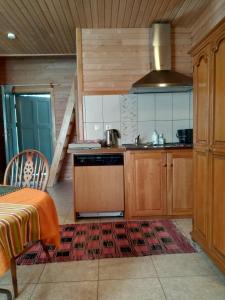 a kitchen with wooden cabinets and a stove at Guest House Pītagi in Košrags