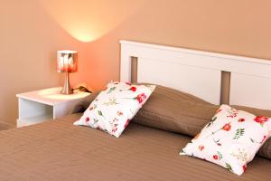 a bedroom with a bed with two pillows on it at UMBERTO I APARTMENTs in Bagheria