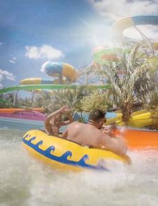 Ein Mann reitet auf einem Floß im Wasser in einem Wasserpark. in der Unterkunft Casas Da Vó Maria in Olímpia