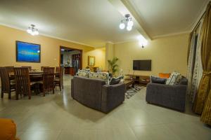 ein Wohnzimmer mit Sofas und ein Esszimmer in der Unterkunft Greens Guest Homes in Mutungo