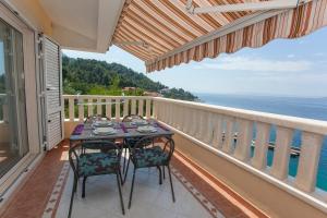 a table on a balcony with a view of the ocean at Villa Filip in Brela