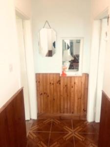 a room with a wooden door and a mirror at Maisie's Seaside Cottage in Quilty