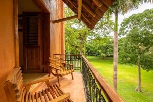 a porch with two wooden benches and a yard at Hacienda Uxmal Plantation & Museum in Uxmal