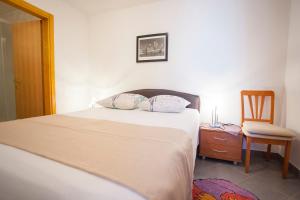 1 dormitorio con cama, silla y escritorio en Villa Filip en Brela