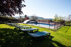 una fila di chaise longue nell'erba vicino alla piscina di Can Cisquet a El Pla de Teyá