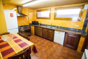 eine Küche mit einem Tisch und einem Waschbecken darin in der Unterkunft Can Cisquet in El Pla de Teyá