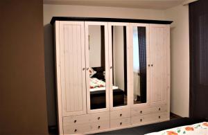 a white cabinet with a mirror in a bedroom at Bella Vita in Uhldingen-Mühlhofen