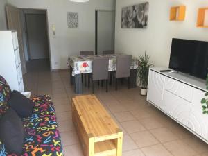 een woonkamer met een tafel en een televisie bij Les iris in Carcassonne