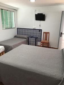 Łóżko lub łóżka w pokoju w obiekcie Hostal Alcobia