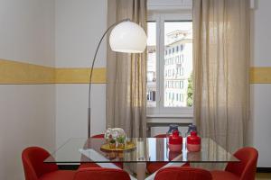 une salle à manger avec une table en verre et des chaises rouges dans l'établissement Casa Zafferano by Wonderful Italy, à Gênes