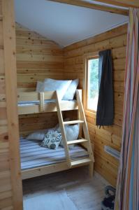 a bunk bed in a log cabin with a window at FAXESTUGORNA in Abbekås