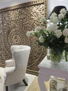 a white chair and a vase of flowers on a table at Boutiquehotel Villa Sissi in Salzburg