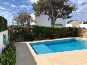 a swimming pool in front of a white house at Llevant 11 E1 in Cala'n Bosch