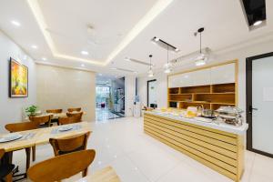 a kitchen and dining room with tables and chairs at Hana 2 Apartment & Hotel Bac Ninh in Bắc Ninh