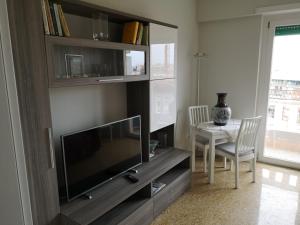 uma sala de estar com uma televisão de ecrã plano e uma mesa em My House in Rome em Roma