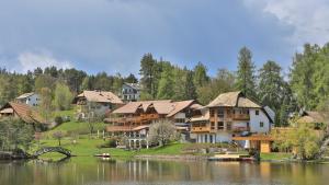 a group of houses on a hill next to a lake at Hotel Weihrerhof in Soprabolzano