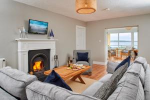 sala de estar con sofá y chimenea en Armada Cottages en Spanish Point