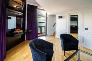 a living room with two chairs and a television at Hotel Europa in Taranto