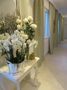 a white vase filled with flowers on top of a white table at Boutiquehotel Villa Sissi in Salzburg