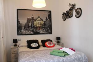 a bedroom with a bed and a painting on the wall at Balcony Apartment Malasaña in Madrid