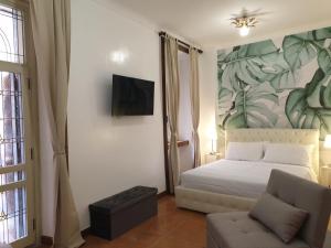 sypialnia z łóżkiem, telewizorem i kanapą w obiekcie Colosseo Smart Flat w Rzymie