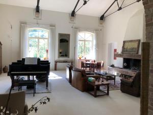 a living room with a piano and a couch at Luxe vakantiewoning in Zuid Frankrijk - Cévennes in Molières-sur-Cèze