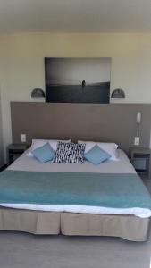 ル・バルカレスにあるHotel de la Plage - Barcaresのベッドルーム(青い枕の大型ベッド1台付)