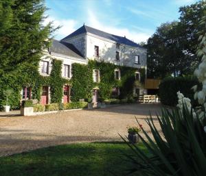 Una casa grande con hiedra a un lado. en Moulin de Gaubourg, en Saint-Mélaine-sur-Aubance