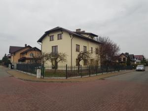 duży biały dom z płotem na ulicy w obiekcie Malinowa 36 Apartamenty w mieście Chojnice