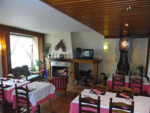 un restaurante con mesas, chimenea y reloj en Hotel Juan Canejan, en Les