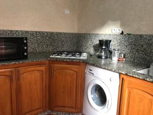 a kitchen with a stove and a washing machine at Wiss Appartement in Essaouira