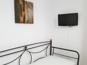 una camera con letto e TV a parete di Ira Apartments a Kamari