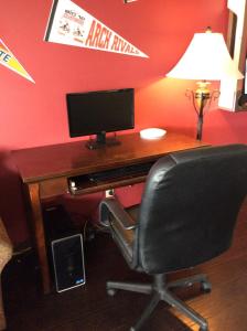 uma secretária com um monitor de computador e uma cadeira em Sports Club Motel em Wayne