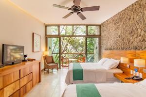 een slaapkamer met 2 bedden en een flatscreen-tv bij Kawilal Hotel in Amatitlán