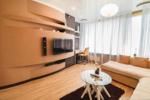 uma sala de estar com um sofá e uma mesa em Apartment-Hotel Panorama em Dnipro