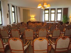 Habitación con filas de sillas y lámpara de araña. en Gäste- und Tagungshaus Maria Trost en Beuron