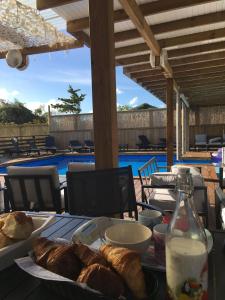 een tafel met een bord brood en een fles melk bij Gîtes La Simonière & Cars in Saint-François