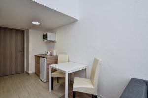 ブダペストにあるHeart of Downtown Apartmentの白いテーブルと椅子が備わる小さな客室です。