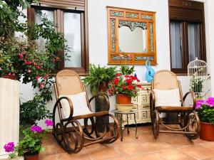 a patio with three chairs and a table with flowers at Casa Turística San Agustín in Córdoba