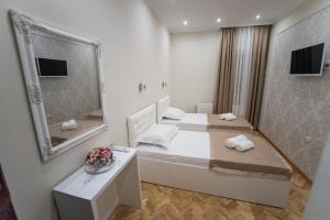 a hotel room with two beds and a mirror at Center Deluxe Garni Hotel in Niš