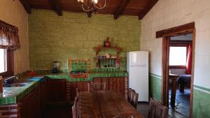 cocina con mesa de madera y nevera en Cabañas Tapalpa Sierra del Tecuan, Cabaña Venado en Tapalpa