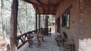 een veranda van een huis met stoelen en tafels bij Cabañas Tapalpa Sierra del Tecuan, Cabaña Venado in Tapalpa