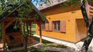 a wooden cabin with a porch and a window at Plitvički San in Korenica