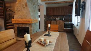 a kitchen with a table with candles and a fireplace at Plitvički San in Korenica