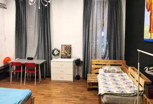 a bedroom with two beds and a desk and a table at Bla Bla Rooms in Krasnodar