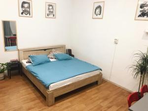 a bedroom with a bed with blue pillows on it at Bla Bla Rooms in Krasnodar