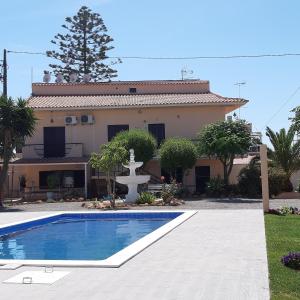 a house with a swimming pool in front of a house at Bela Alexandra Guest House in Fuzeta