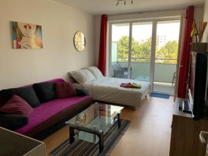 Una sala de estar con un sofá morado y una mesa. en Apartment Fiala, en Olomouc