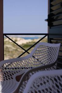 a white bench sitting in front of a window at Supertubos Beach Hostel in Peniche