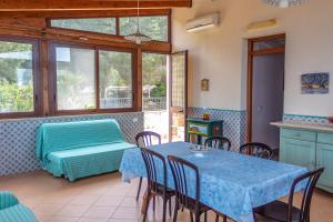 a room with a table and chairs and a bed at Villa Verde con vista sul mare in San Vito lo Capo
